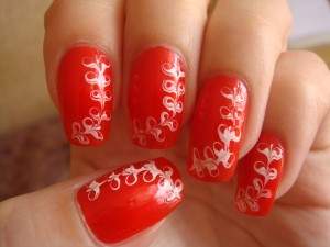 Дизайн ногтей с белыми цветочками на красном фоне